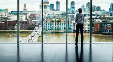 Businessman looking out window at London