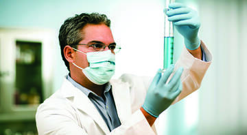 Researcher looking at liquid in beaker