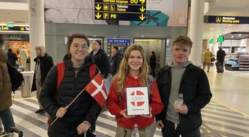 Students with the Denmark flag in the airport