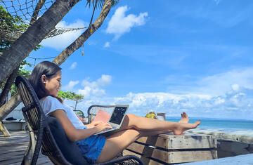 female-pax-on-laptop-seaside-cafe-with-a-beach-view.jpg