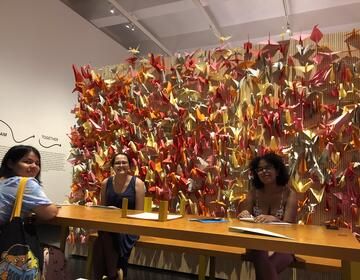Students working on origami in the Hello Happiness exhibit