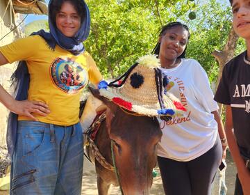 Marly and Ja'Niya posing with the family donkey