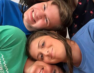 Four Smiling Faces Look at the Camera