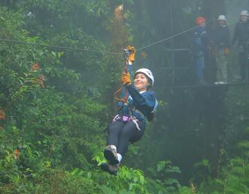 Women for Environmental Action student, Karina, ziplining across the cloud forest and smiling