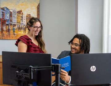 Students in front of computers looking at CIEE notebook