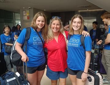 Host family and high schoolers posing at airport