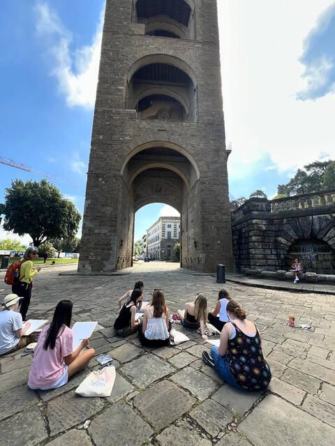 Student group drawing building outside