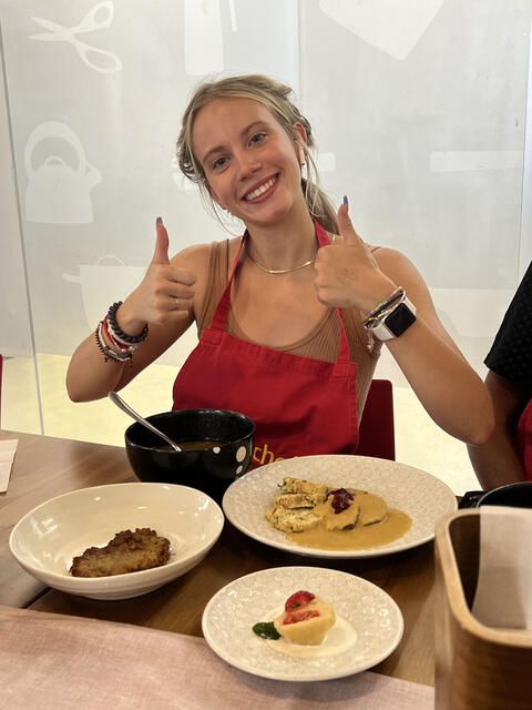 High school girl giving thumbs up during cooking class 