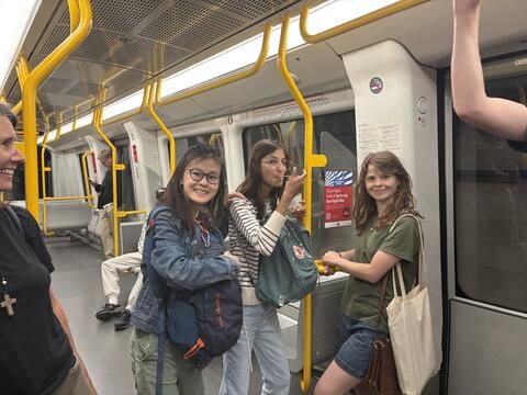 Students stand on the metro 