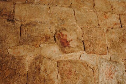 Red handprint on the wall of an arch in Uxmal
