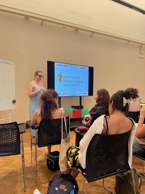 teacher at front of class of high school students presenting 