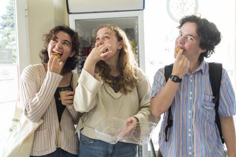 High schoolers on program tasting pastries and smiling