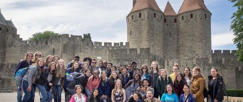 High school students in a group photos in front of a castle in Toulouse