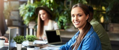 young woman waving a working meeting at a coffeeshop with coworker
