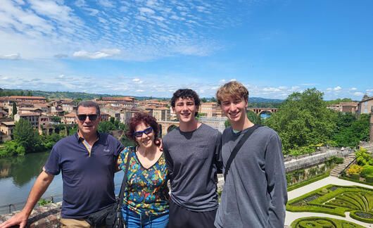 High school students with their host family touring gardens