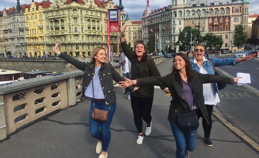 Prague girls on bridge with their hands out
