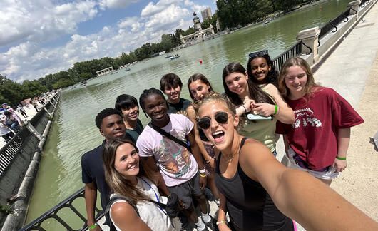 Program leaders and students posing by lake in Mardid