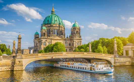 Berlin Cathedral with boat going under bridge.