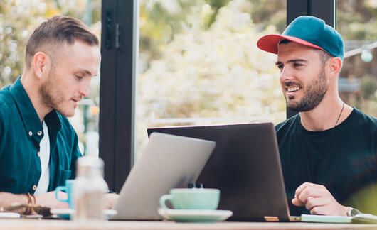 auckland two young men on laptops at long table