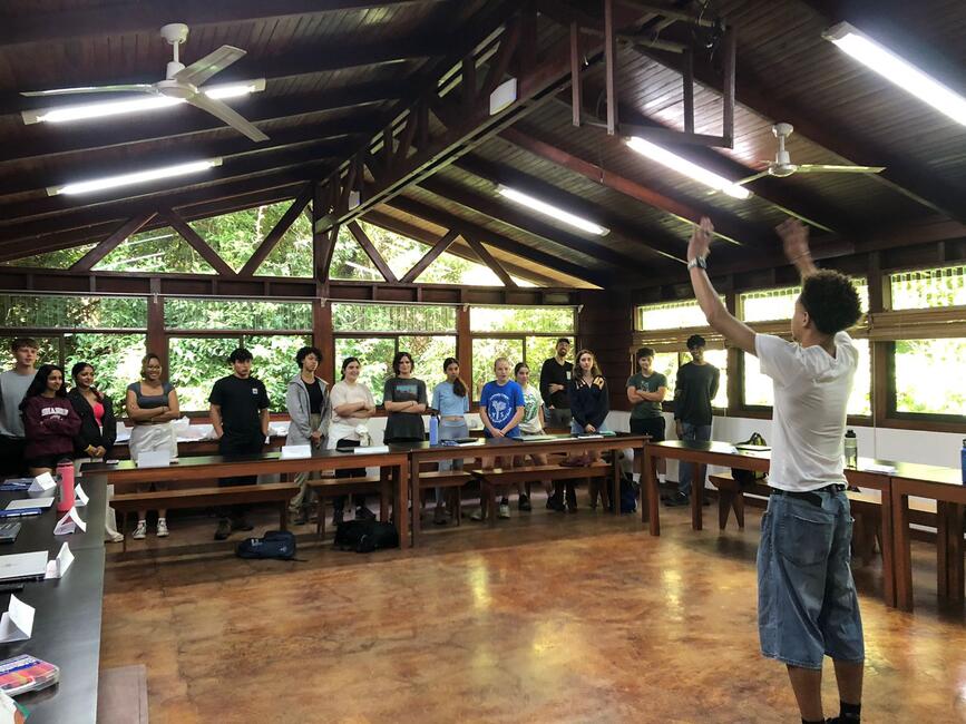 A student leads a review charades game in their Climate Change Mitigation class.