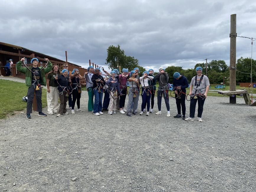 Students pose for a photo before taking on the high ropes course.