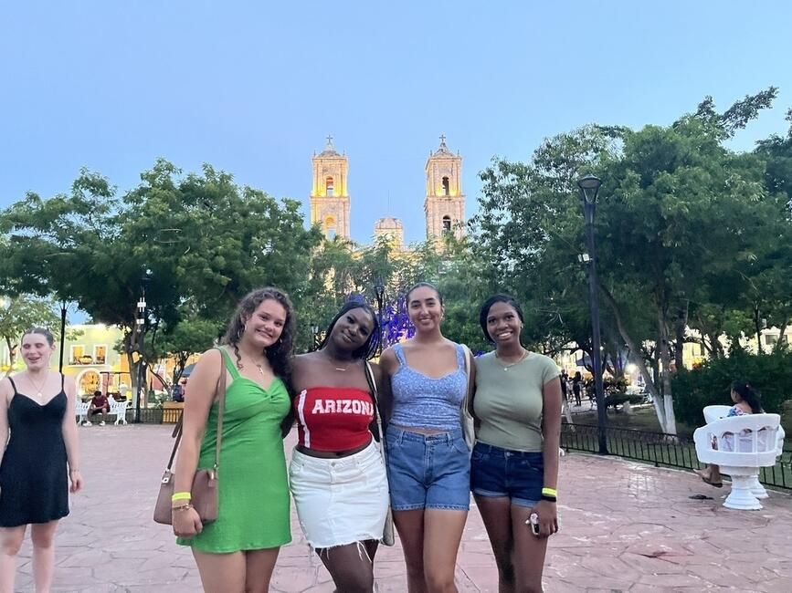 High school study abroad students in a park in front of a historic cathedral