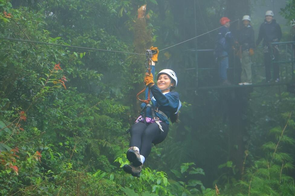 Women for Environmental Action student, Karina, ziplining across the cloud forest and smiling