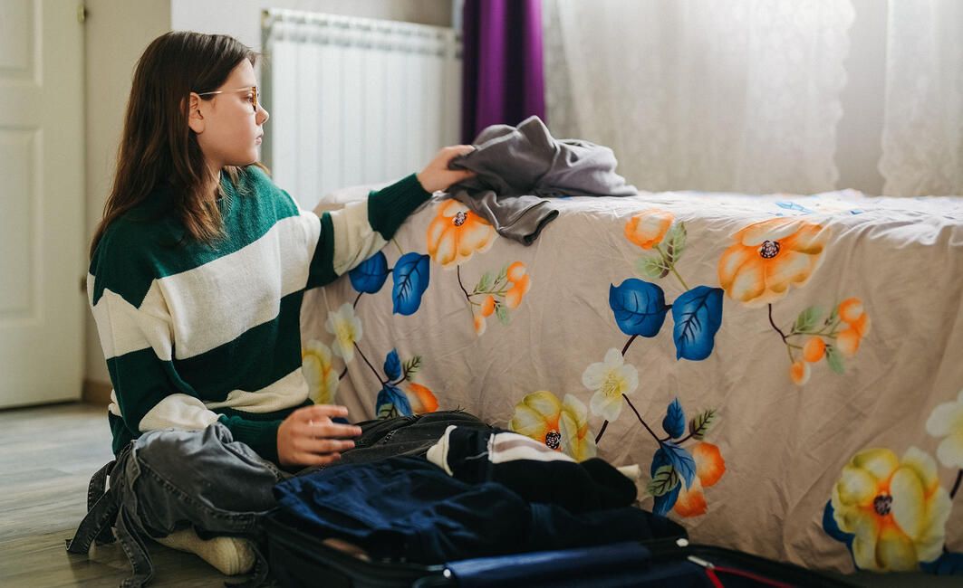 Girl packing suitcase before going abroad