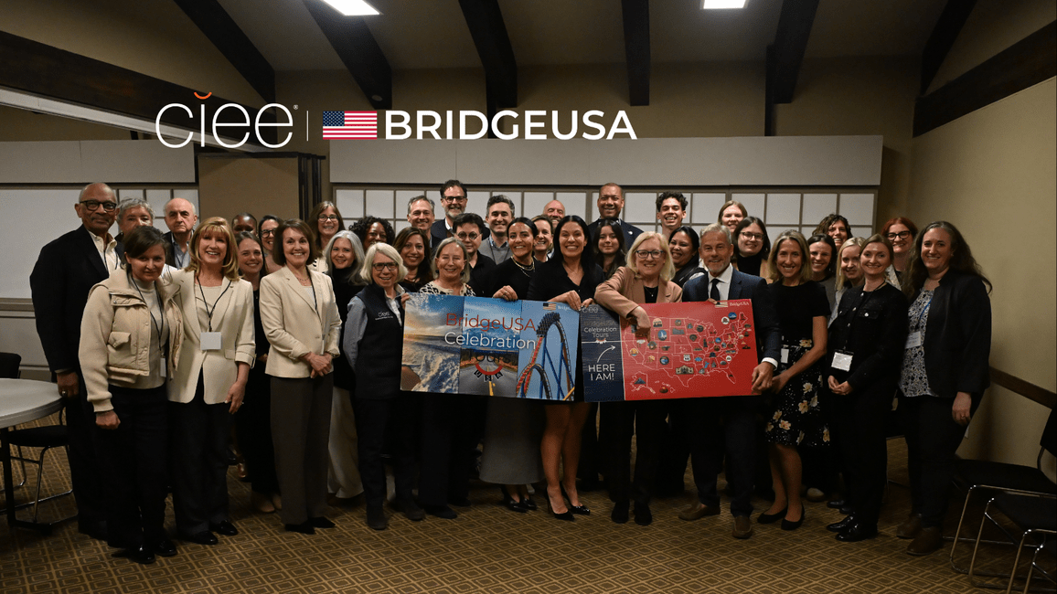CIEE staff, host employers, and community partners gather for a group photo during the BridgeUSA Celebration Tour event in Park City, Utah, holding a BridgeUSA Celebration banner.
